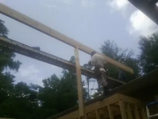 Carpenter setting a ridge beam over a new addition frame — Ice Dam Removal by Roofing Brothers in Littlestown