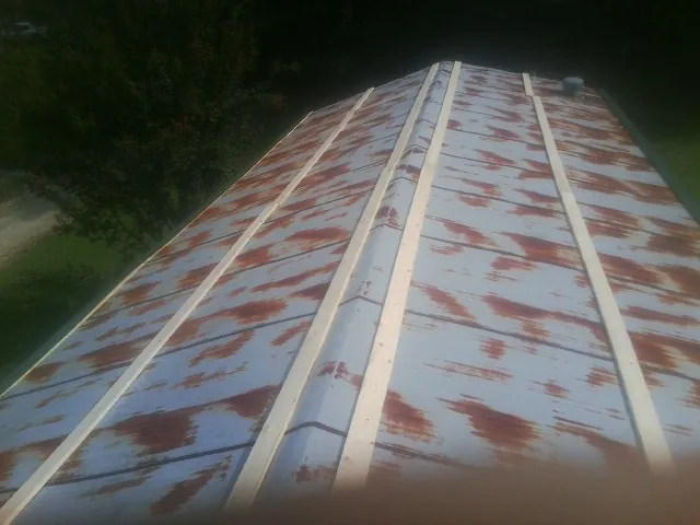 Rusted metal roof panels with new wood purlins before replacement — Storm Damage Roof Repair in Littlestown by Roofing Brothers