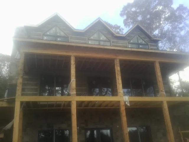 Dormers and porch framing on a large log home under construction — Roof Coating work by our crew in Littlestown