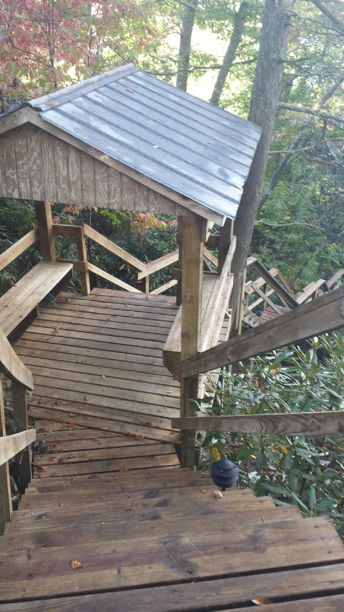 Metal roofed shelter over wooden steps on a wooded walkway — Skylight Repair & Installation work by our crew in Littlestown